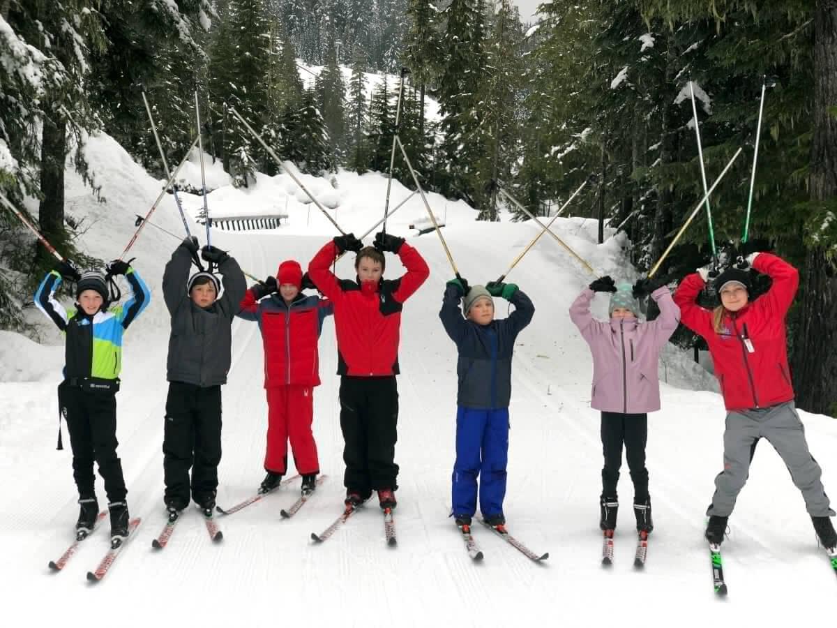 children holding up ski poles in ski camp