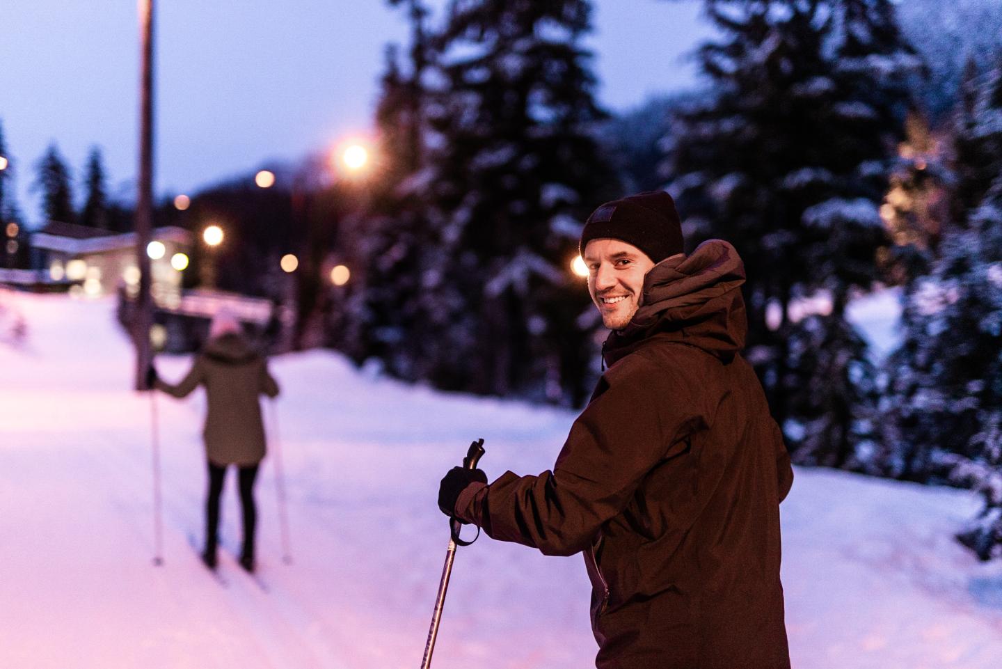 Man skiing and smiling, outside in winter at night