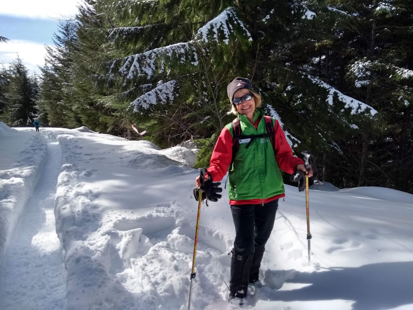 Volunteer standing on snowy trail smiling