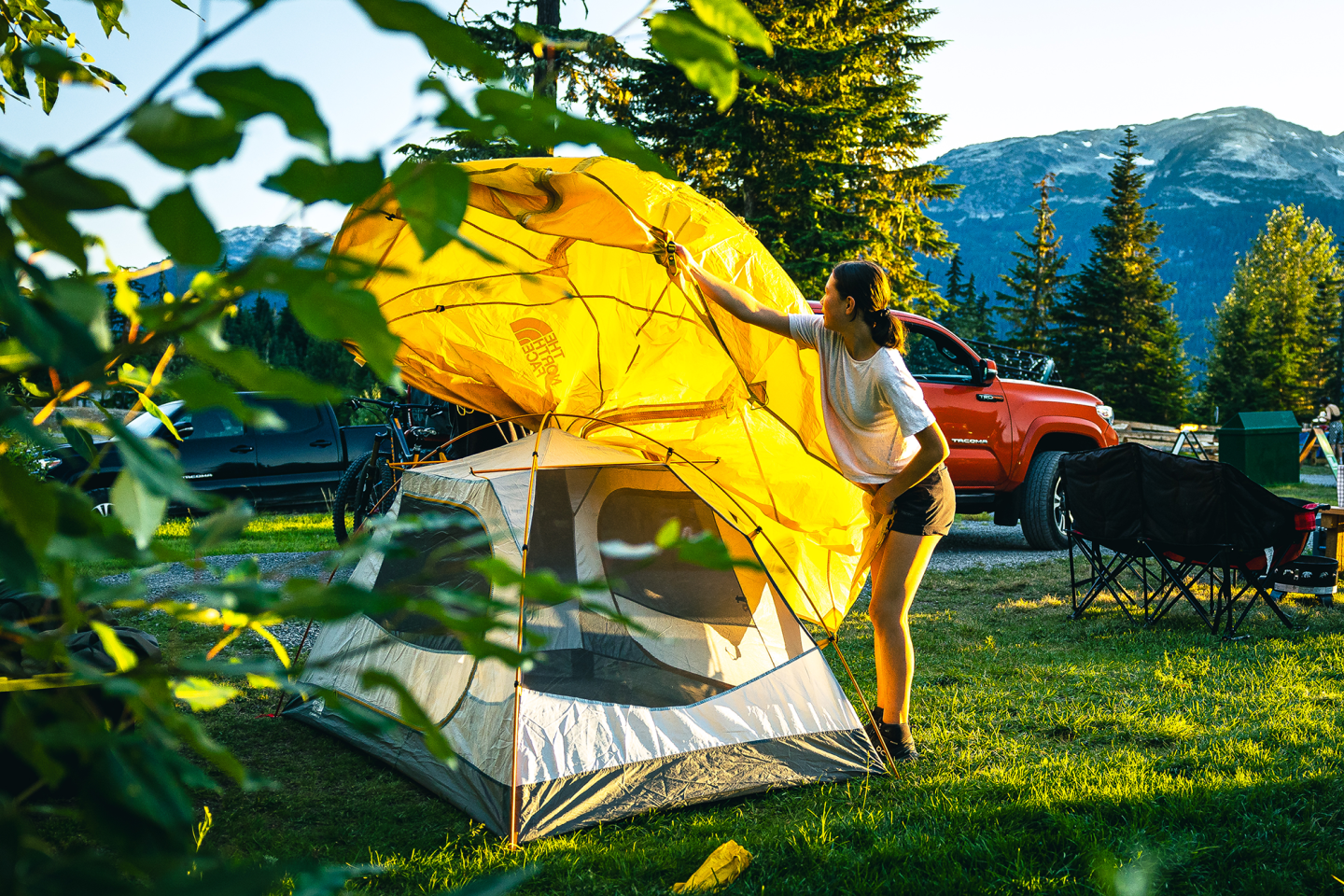 woman setting up tent, throwing tarp over the top