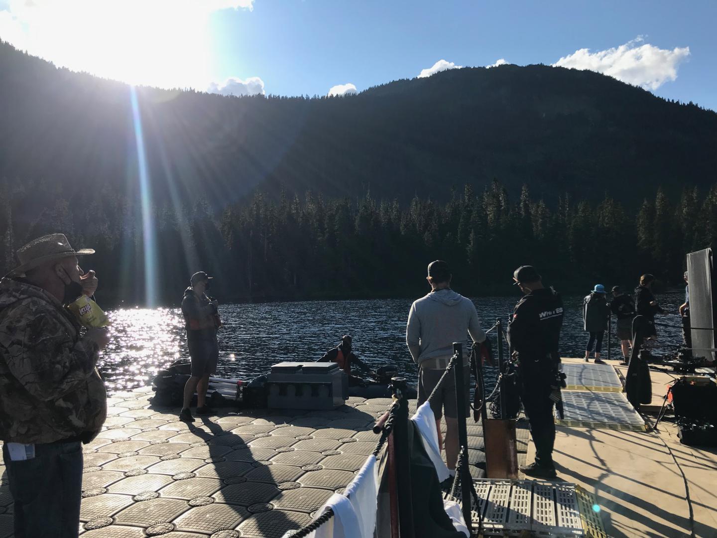 Camera crew setting up beside mountain lake