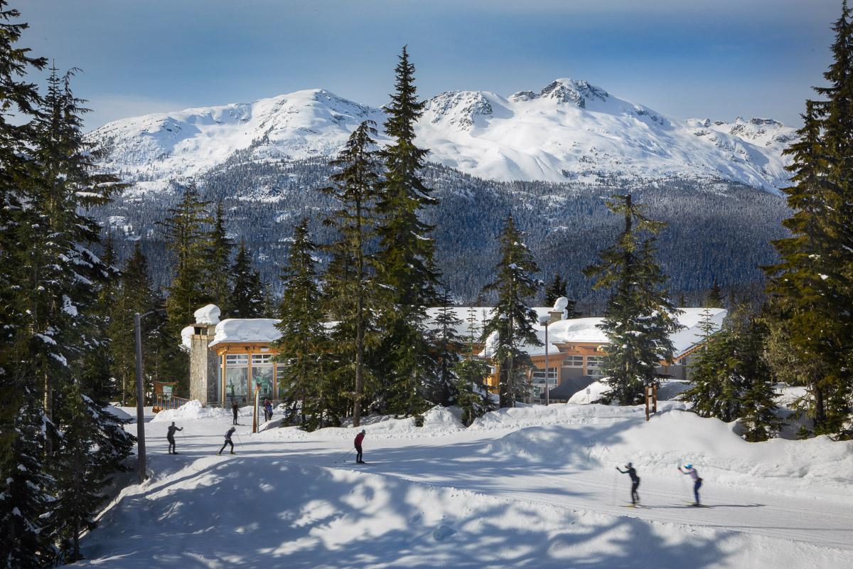 skiers on trail with mountains in the background
