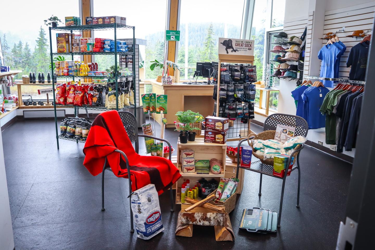 Whistler Olympic Park Summer Store interior with snacks, clothing, and camping gear displayed on racks and tables.