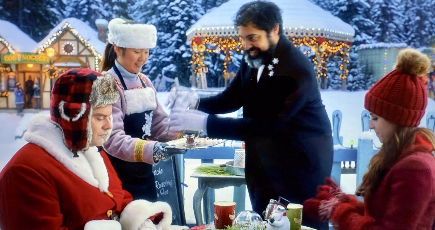 People in winter clothing at a festive outdoor market.
