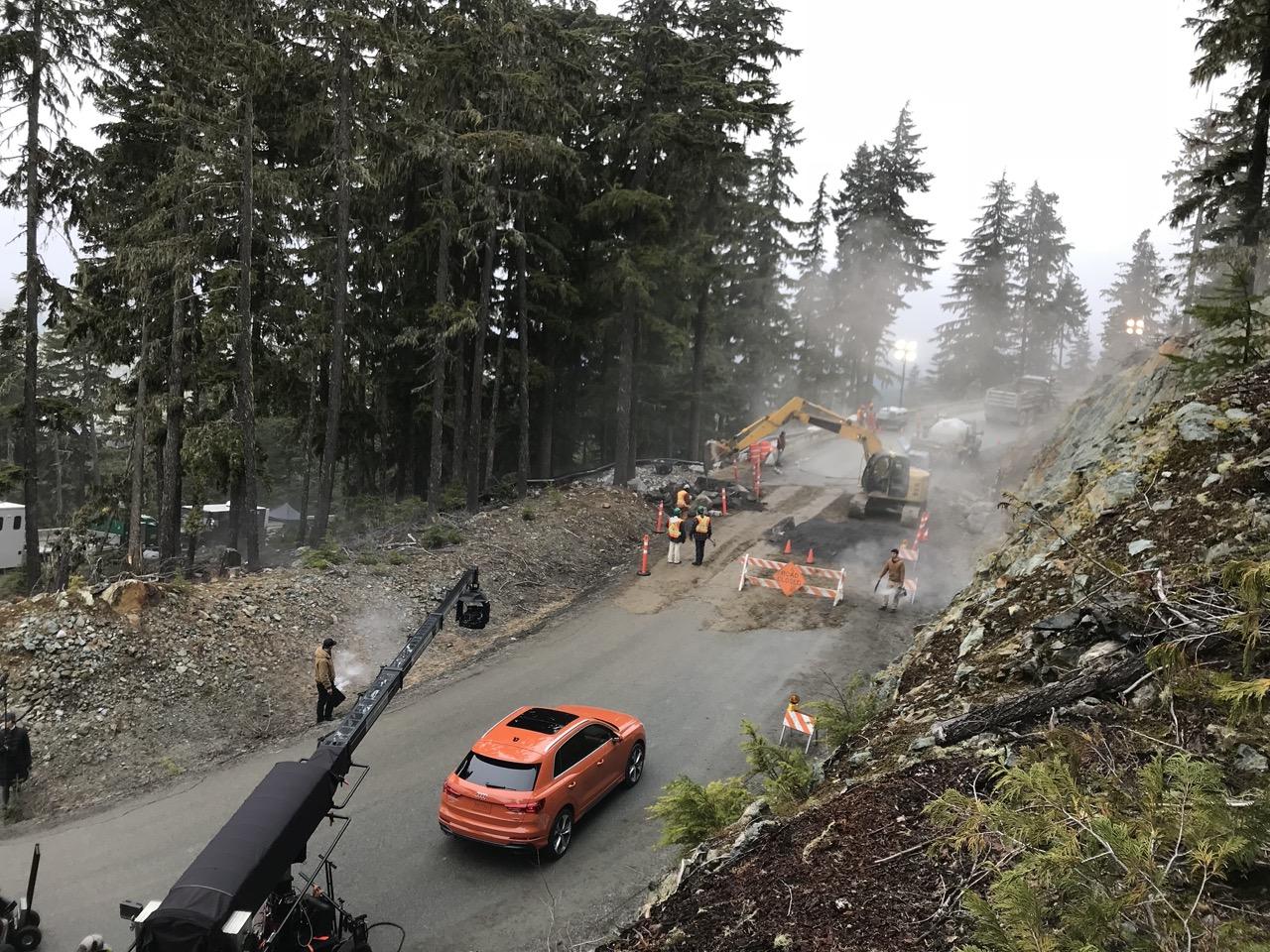 Road construction scene with orange car, trees, and fog.