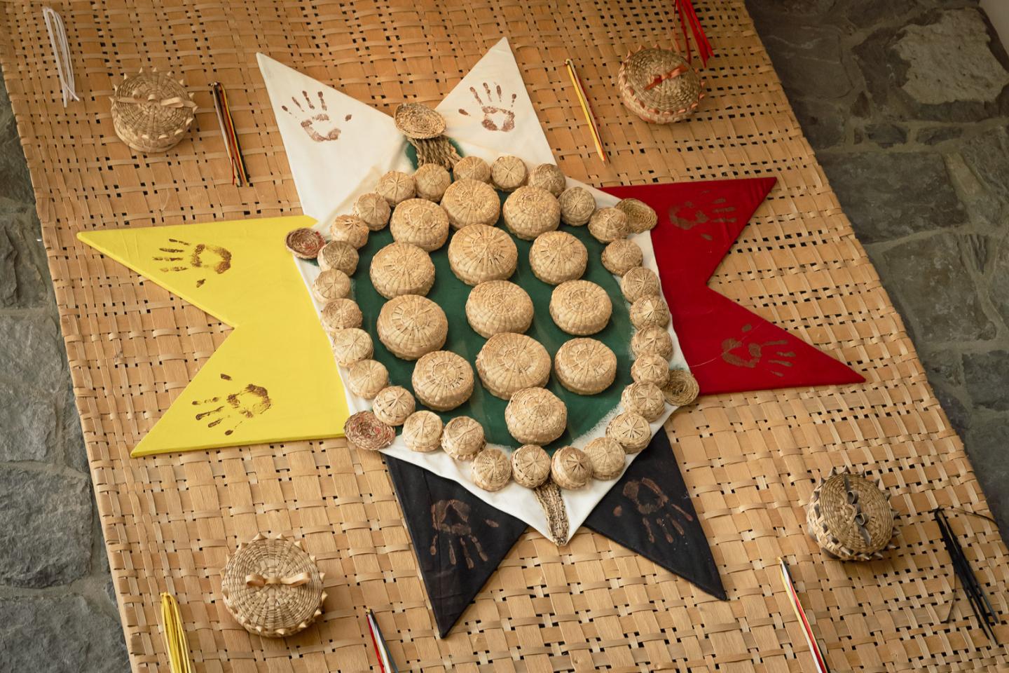Round cookies arranged on colorful star-shaped mat with handprints and patterns.
