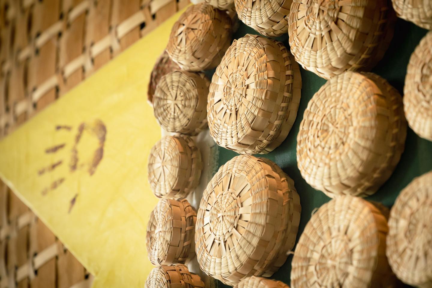 Woven baskets arranged in a circular pattern on a textured wall.