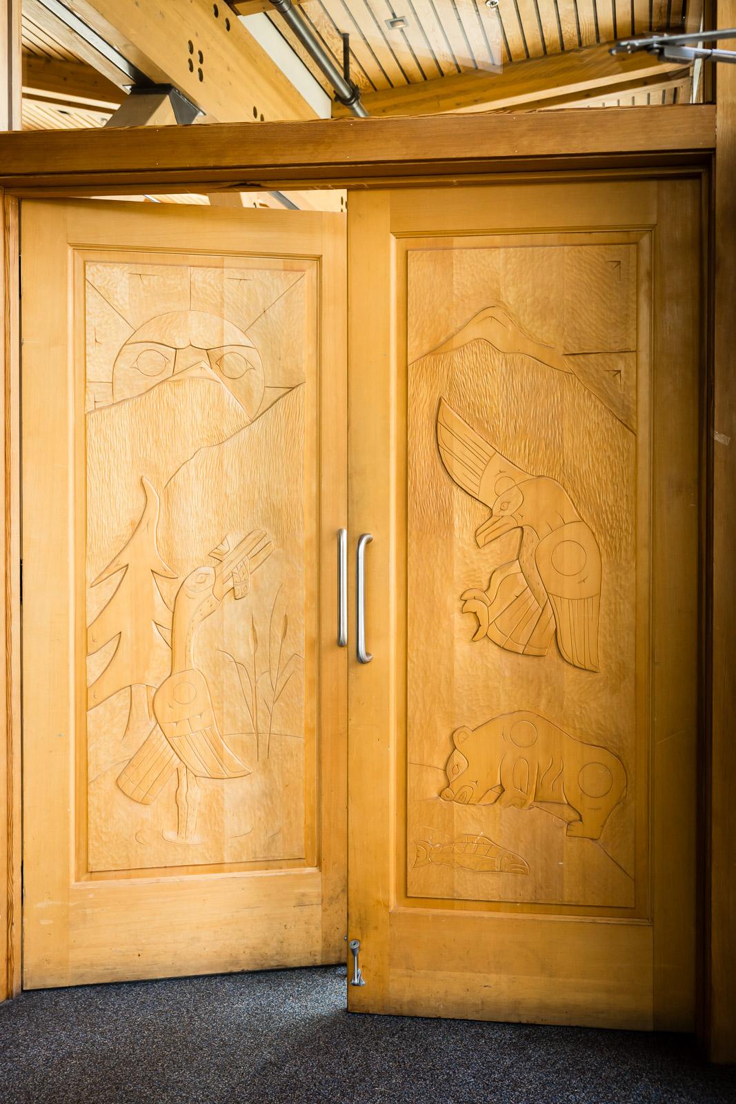 Wooden double doors with carved animal designs.