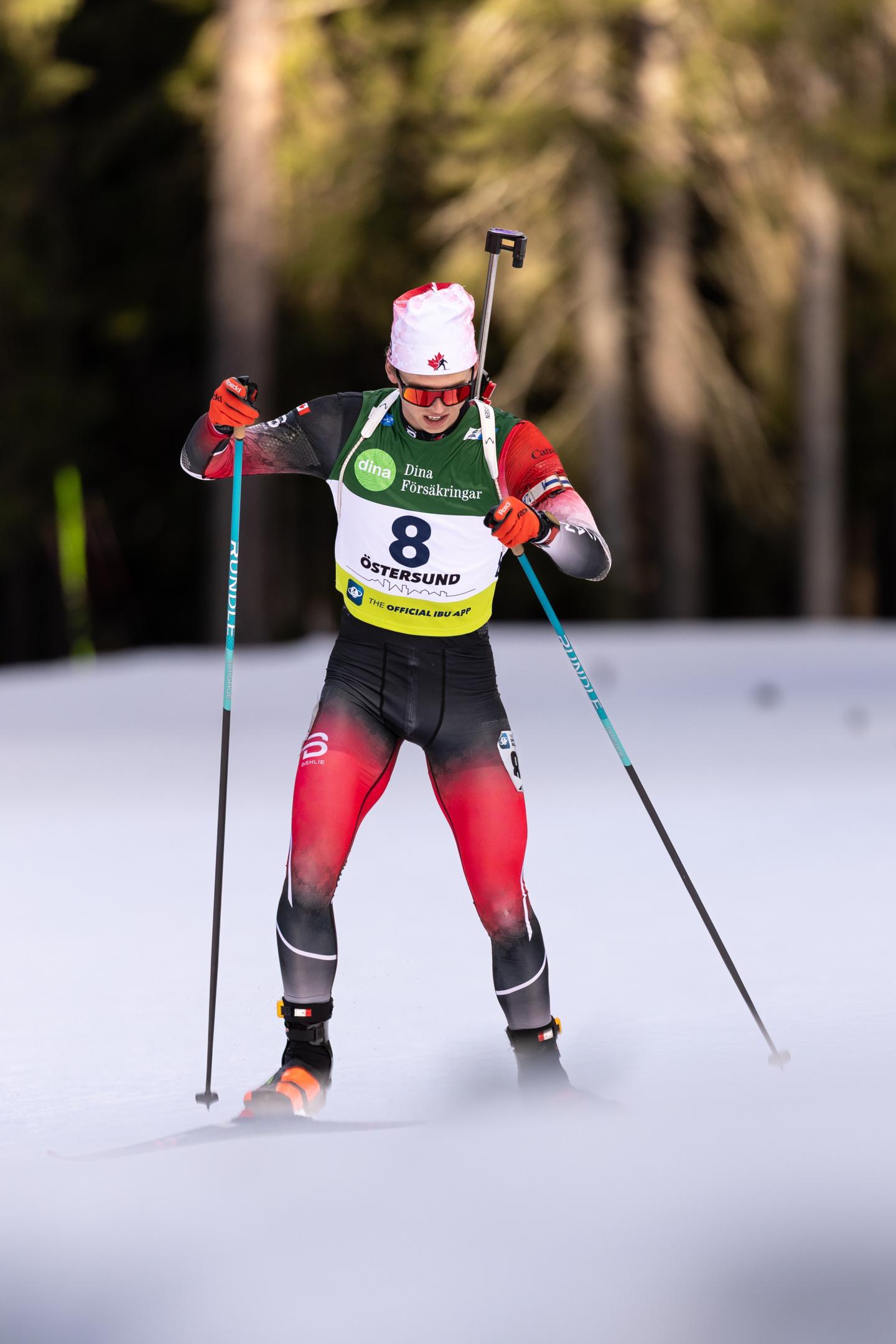 Jasper Fleming Cross-country skier in a race on a snowy trail, wearing red and black gear.