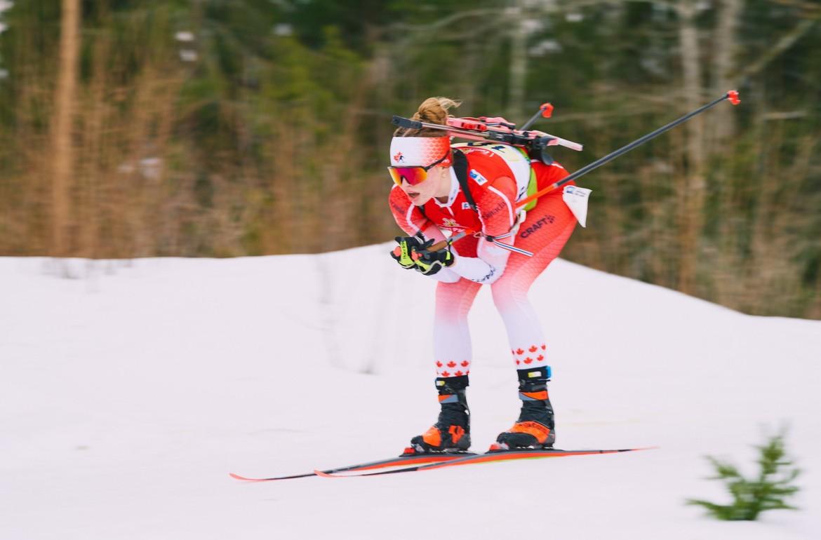 Mia Rogers Cross-country skier in red and white gear on snow, holding ski poles.