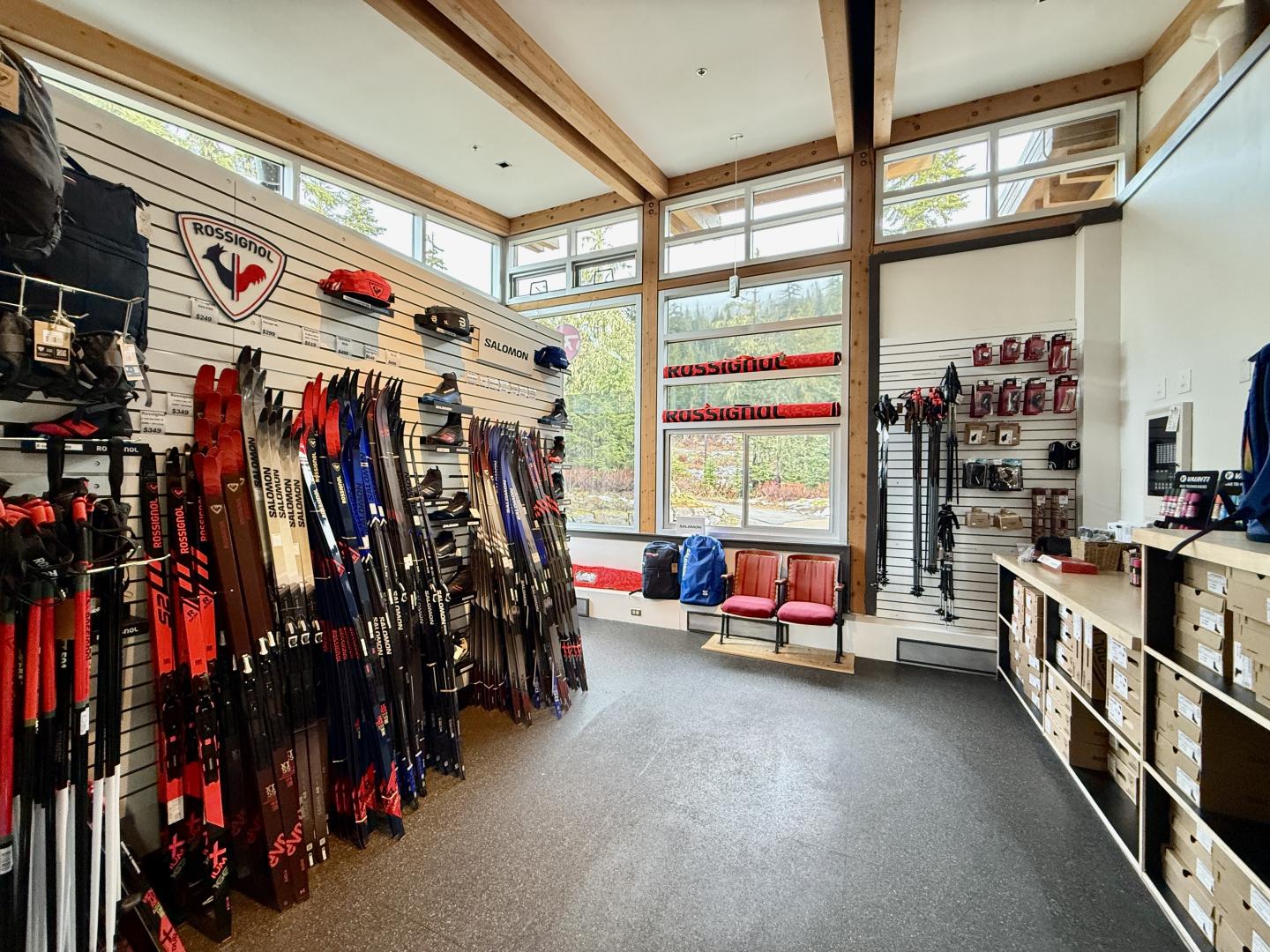 Ski shop interior with gear on display, large windows, and wooden beams.