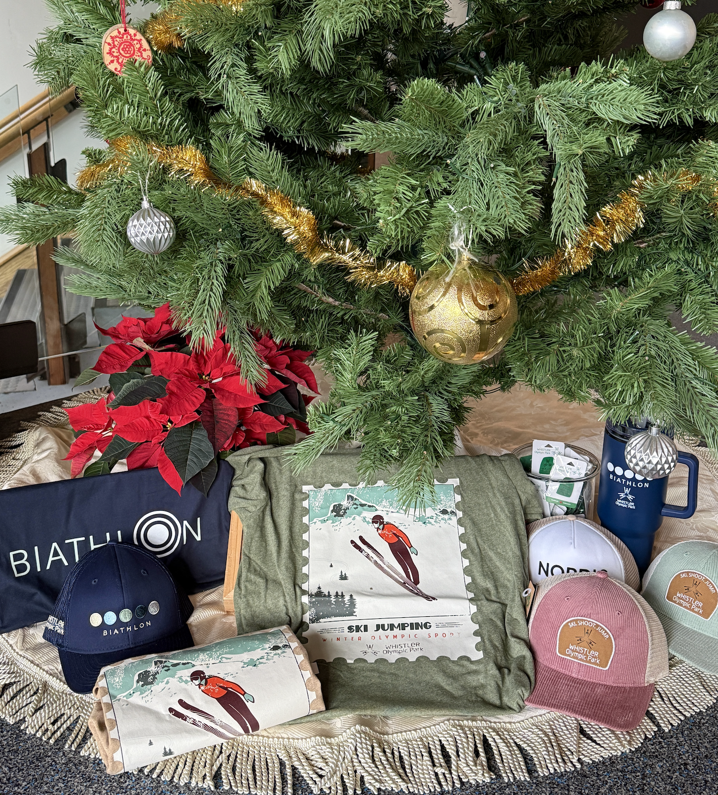 Holiday-themed gifts under a decorated Christmas tree with a gold garland.