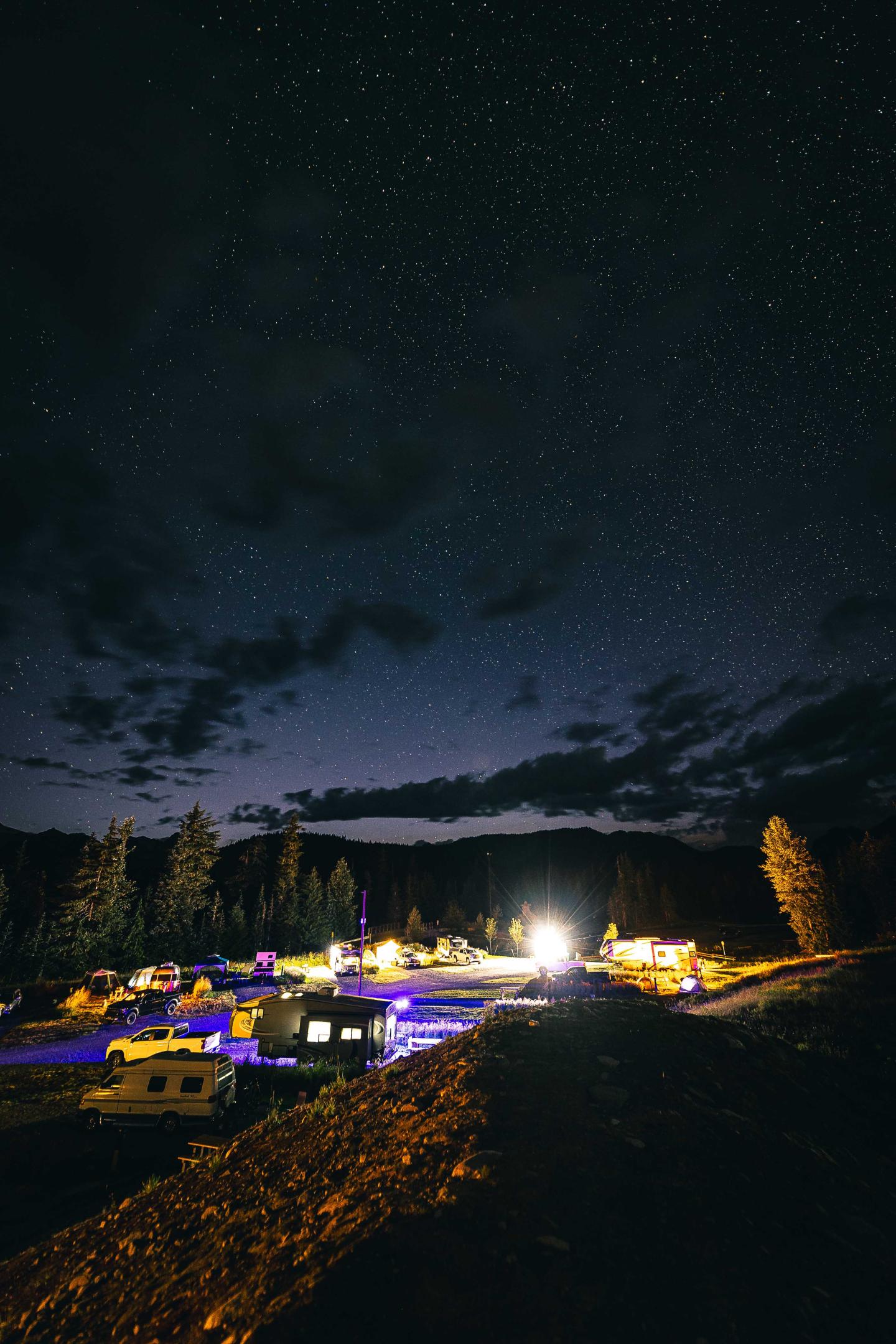 Whistler Olympic Park Starry night sky over a brightly lit campground in a forested area.